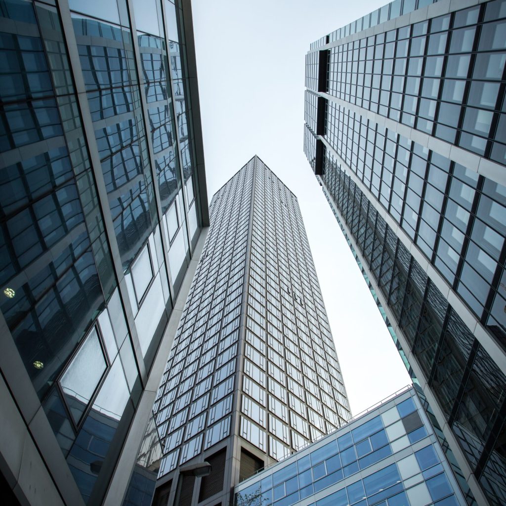 A vertical low angle shot of high rise skyscrapers in a glass facade in Frankfurt, Germany